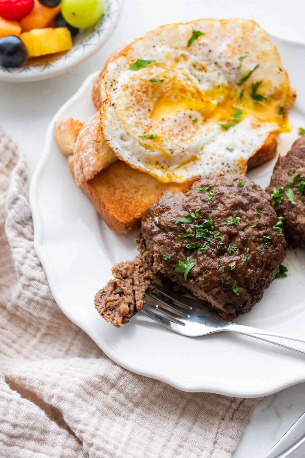 A plate with eggs and a sausage patty.