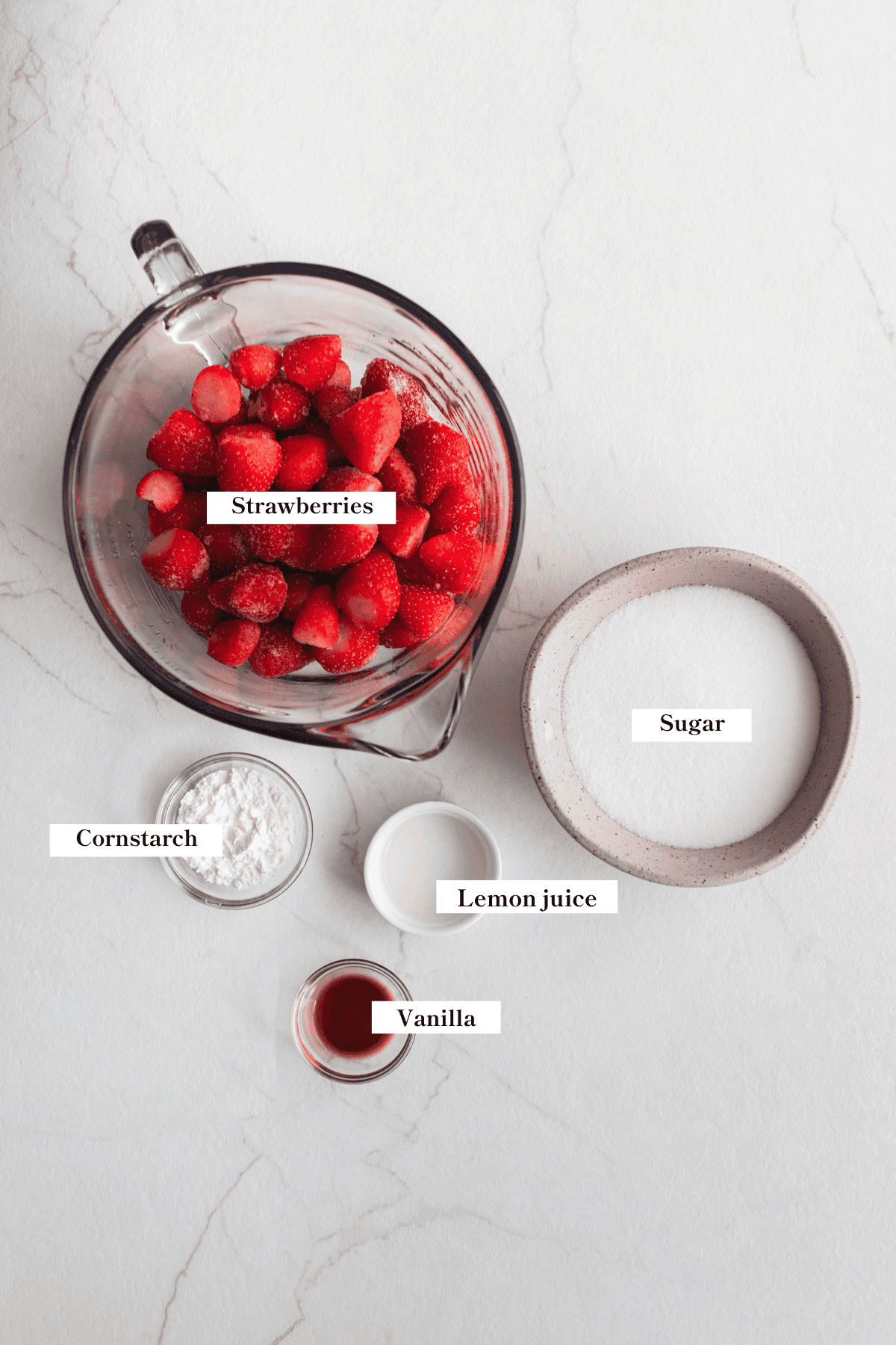 Ingredients for strawberry sauce on a counter top.