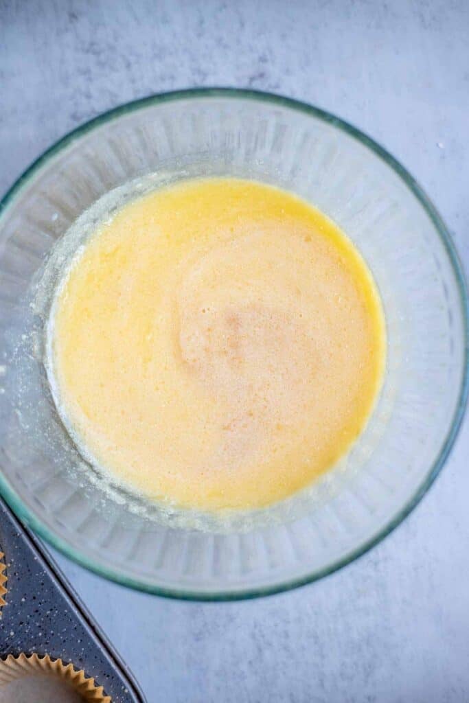 butter, eggs, and sugar mixed together in a glass bowl.