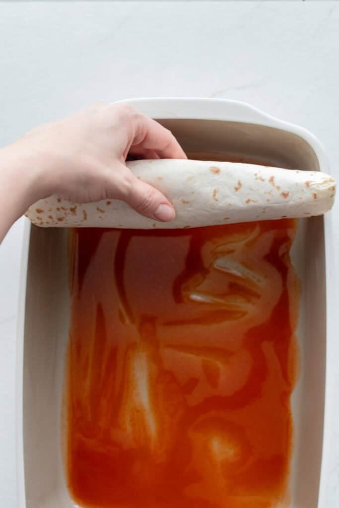 Placing a tortilla in the pan.