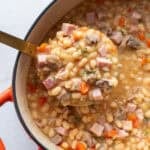 A ladle full of soup from a dutch oven.
