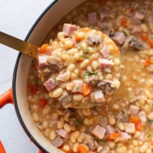 A ladle full of soup from a dutch oven.