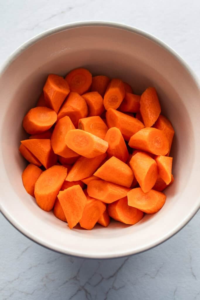 Carrots chopped into bite sized pieces in a bowl.