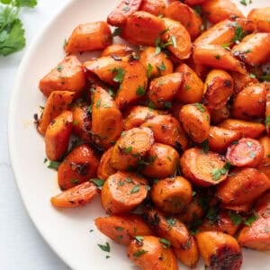 A plate full of carrots chopped into bite sized pieces.