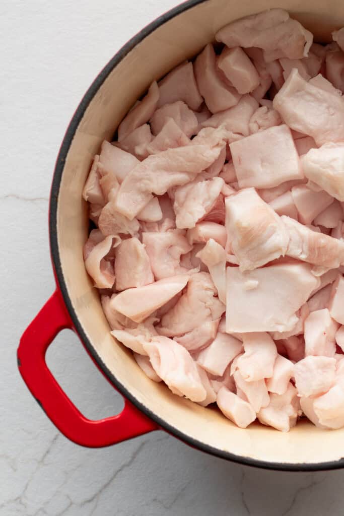 cubed pork fat in a cast iron dutch oven on the stove top.