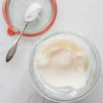 lard stored in a glass container with the lid sitting off to the side.