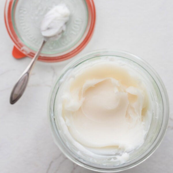 lard stored in a glass container with the lid sitting off to the side.