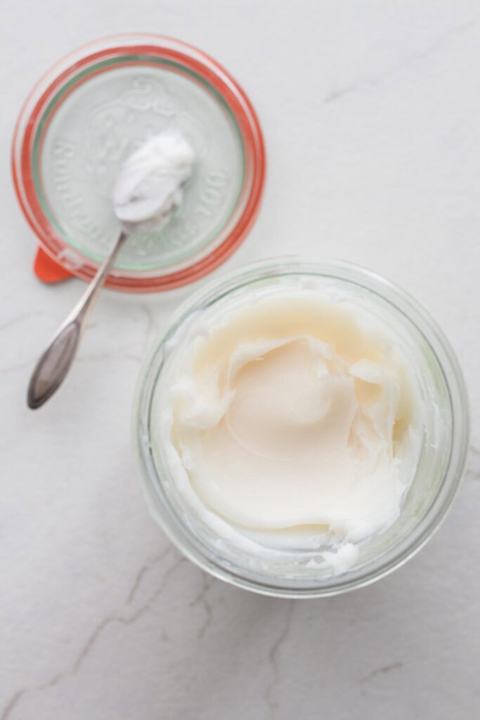 lard stored in a glass container with the lid sitting off to the side.