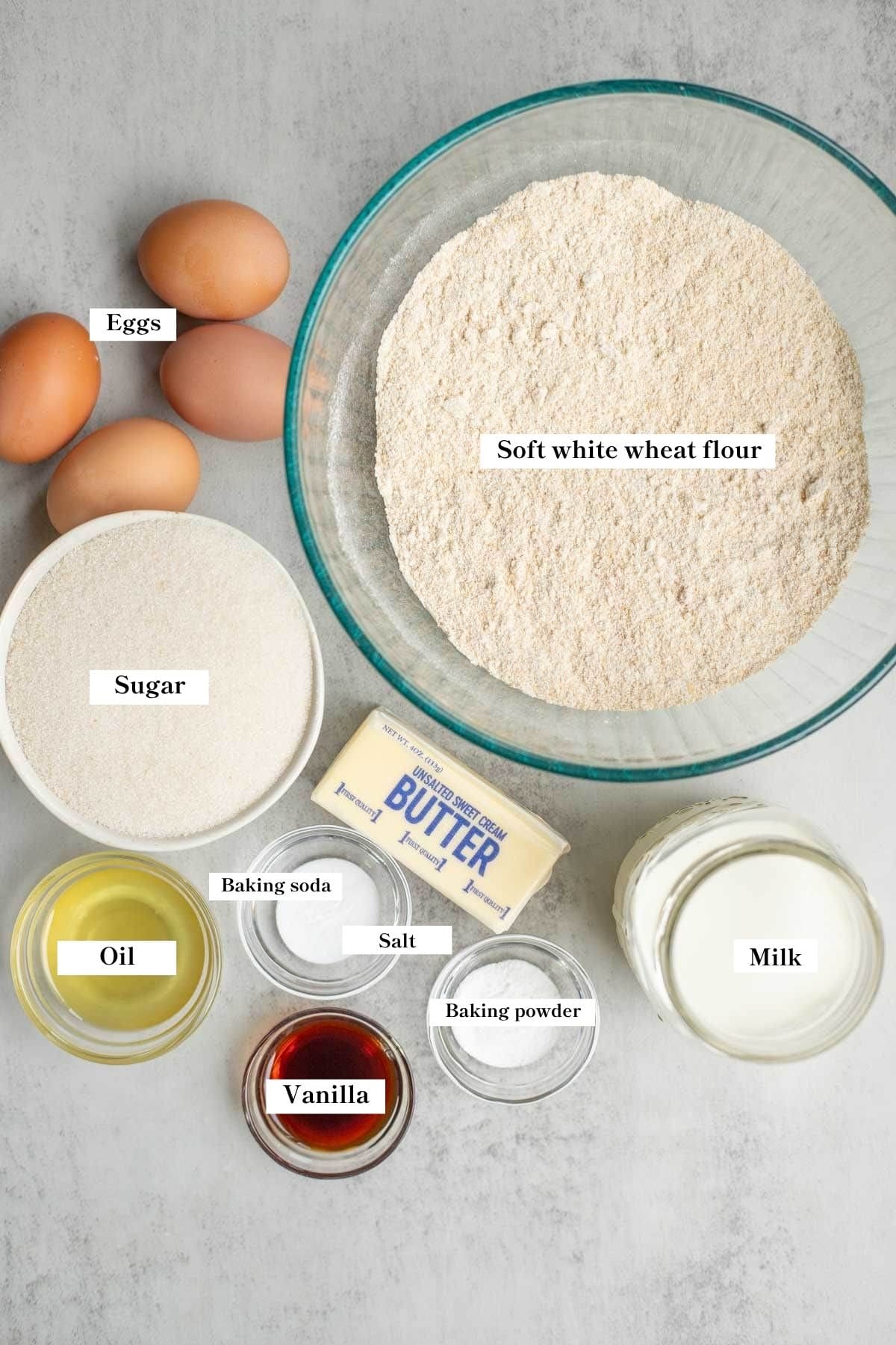 ingredients in small bowls on the kitchen counter to make a whole wheat cake.