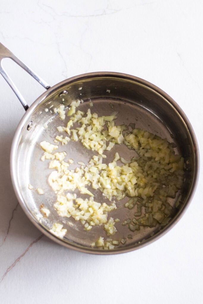 A skillet with onion and garlic.