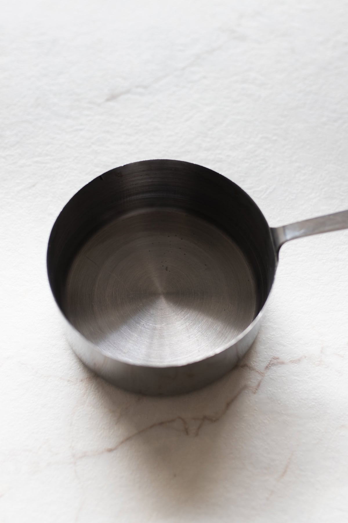 A sauce pan with water in it on a counter top.