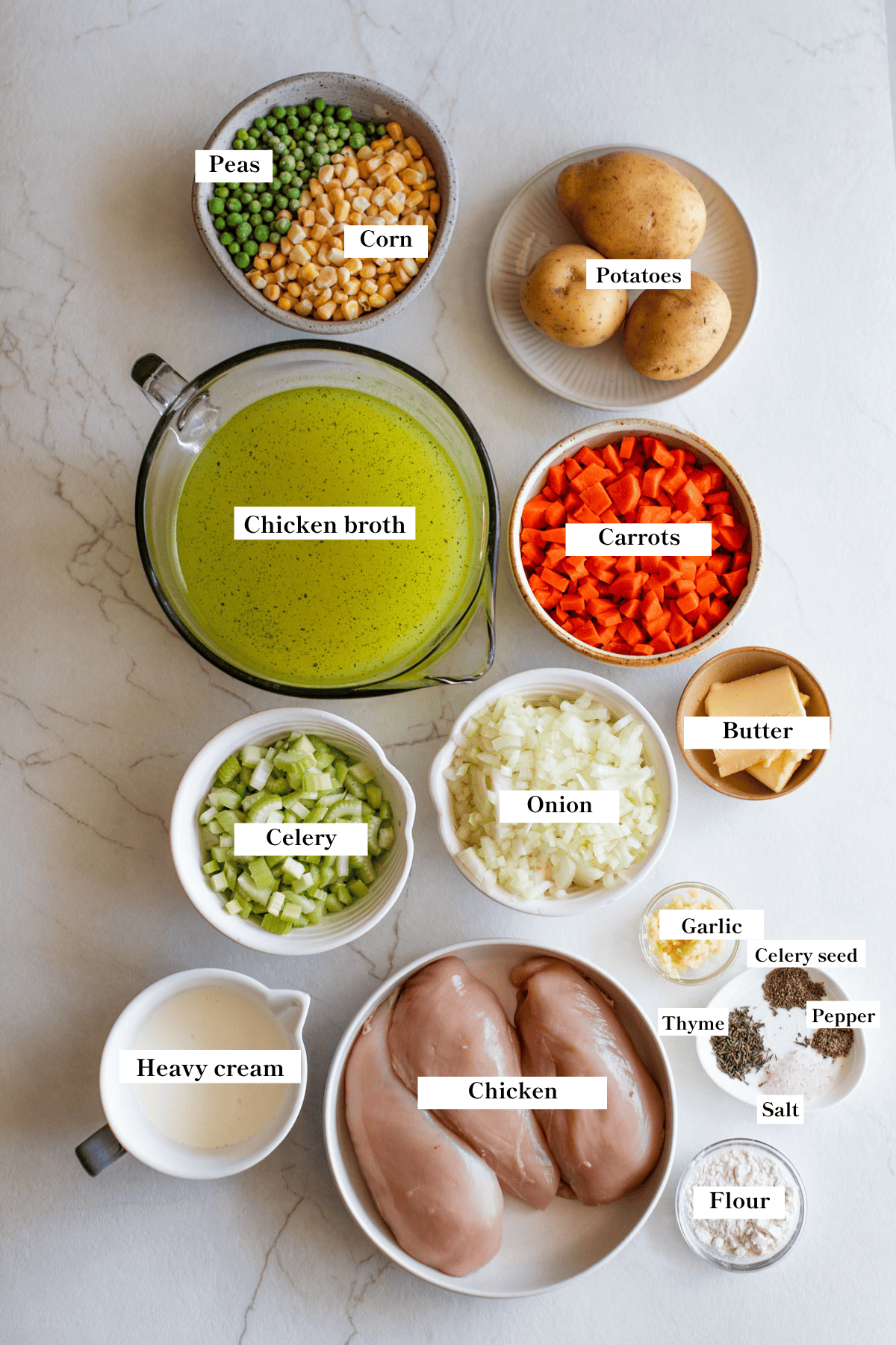 Ingredients for soup in various sized bowls on a counter top.
