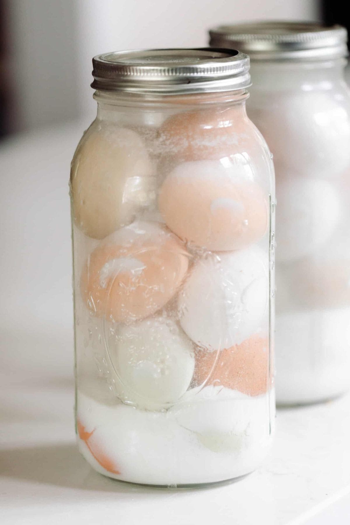 Two jars with eggs in a lime solution.