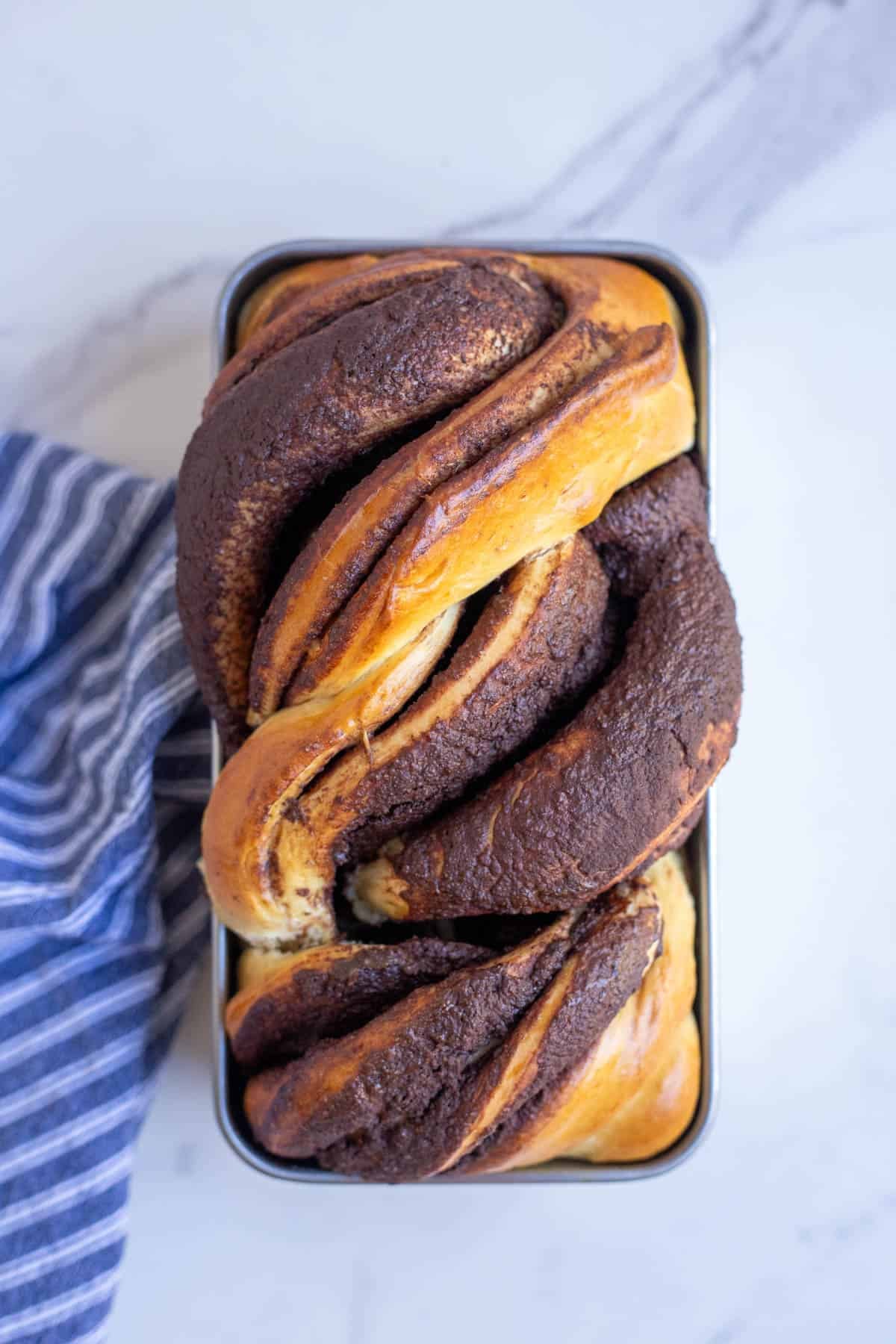 Freshly baked sourdough babka on a marble countertop.