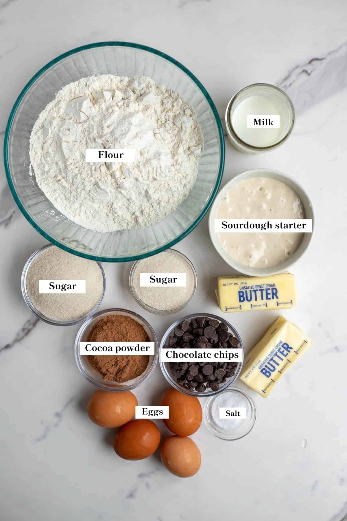 Ingredients for sourdough babka in small bowls on a marble countertop.