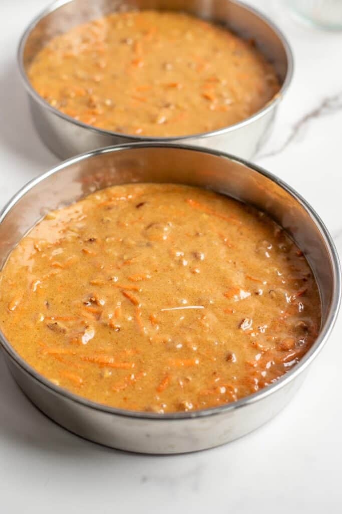 sourdough carrot cake batter poured into two 9" round cake pans.