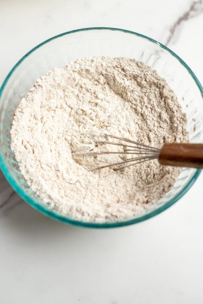 dry ingredients to bake a cake whisked together in a glass bowl.