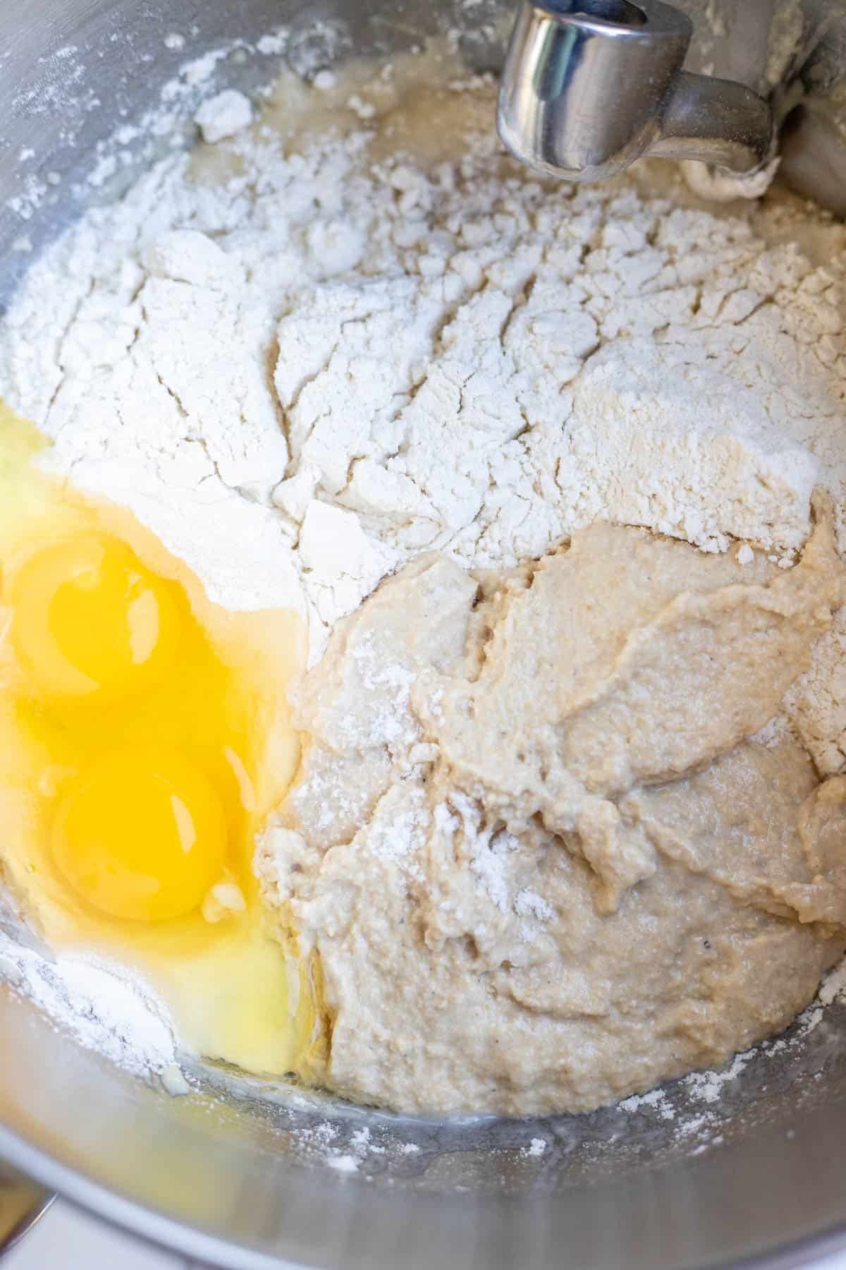 Flour, starter, salt, and eggs added to a stand mixer.