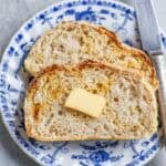 Two slices of english muffin bread on a blue and white plate.