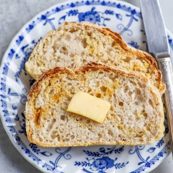 Two slices of english muffin bread on a blue and white plate.