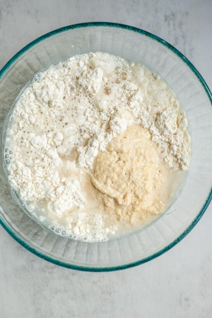 A bowl with flour and sourdough starter in it.