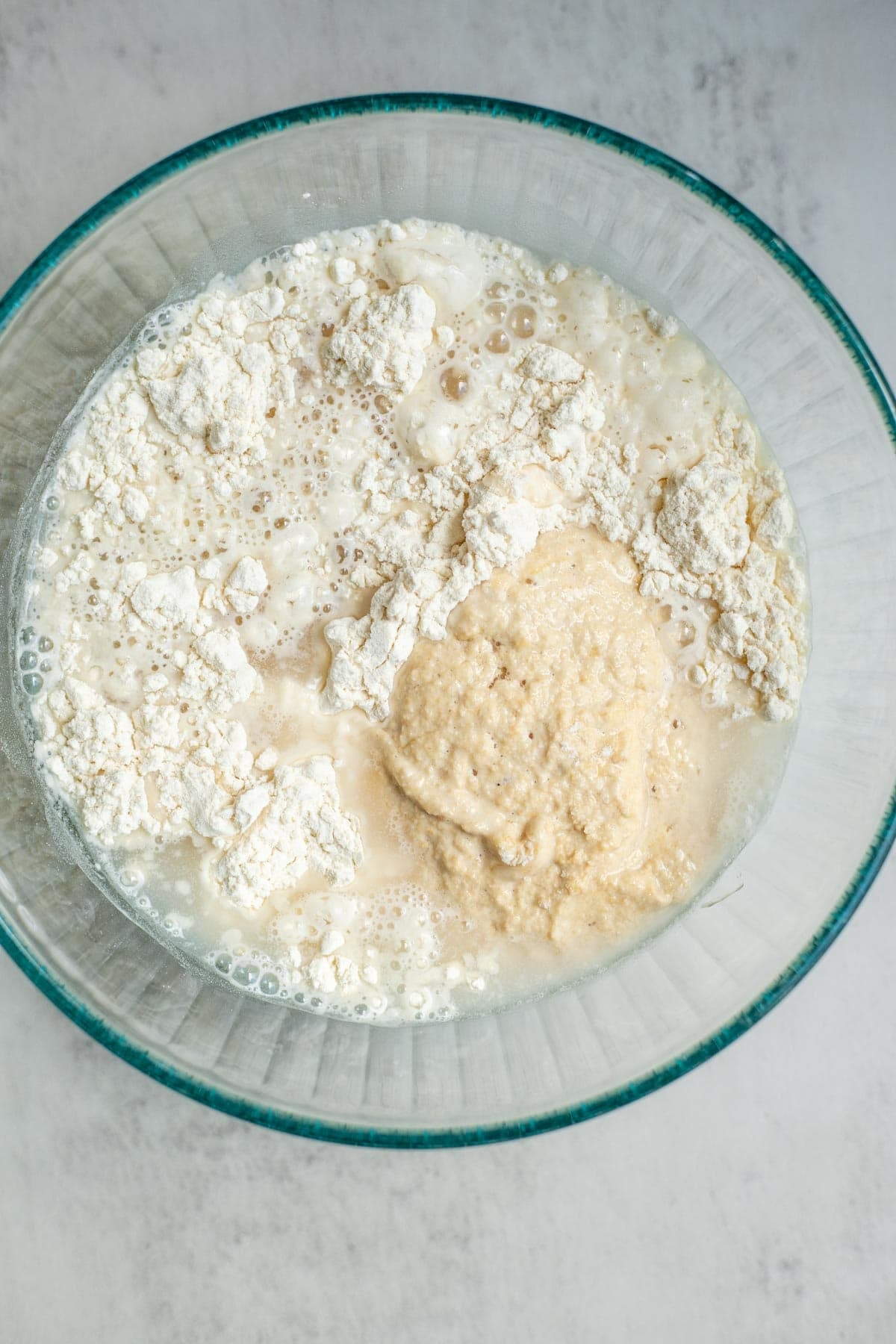 A bowl with flour and sourdough starter in it.