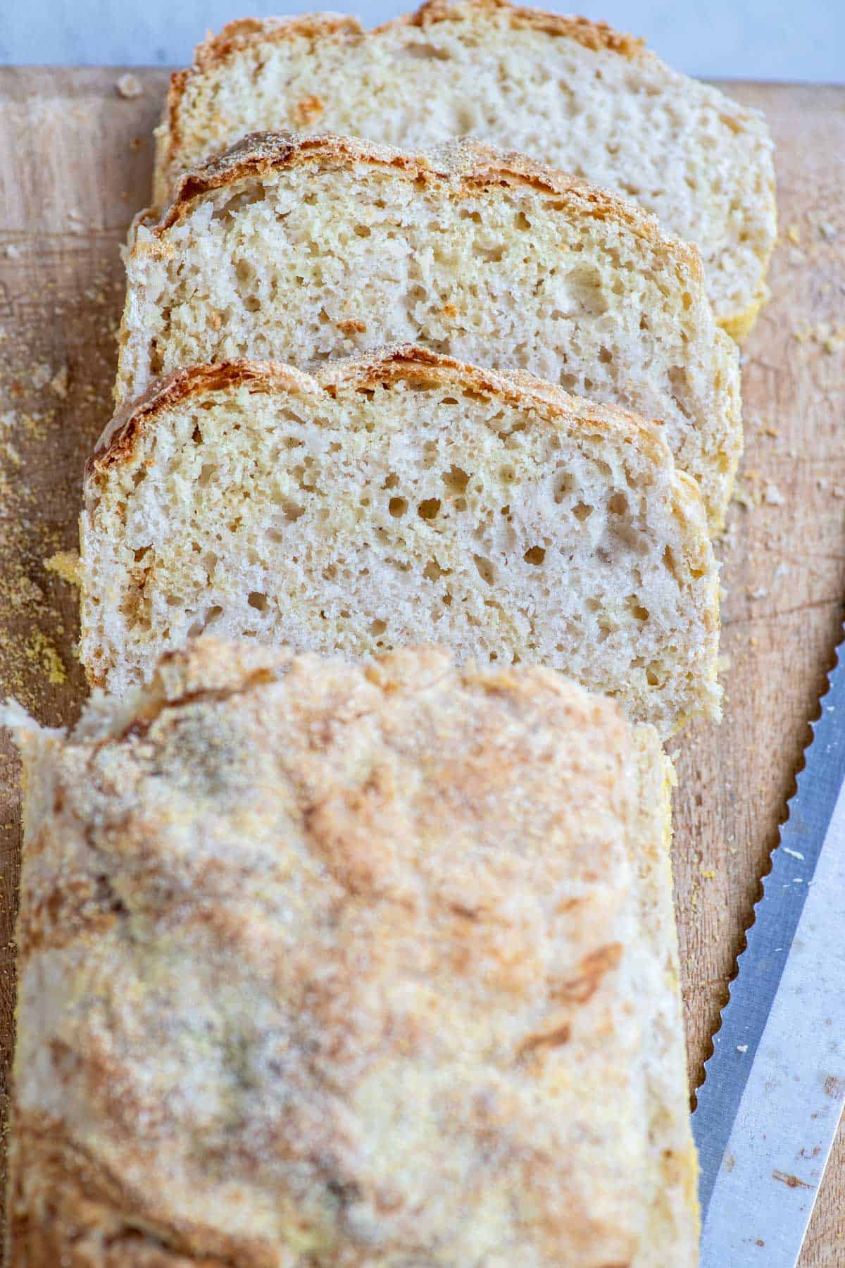 Three slices of a loaf of English muffin bread on a cutting board.