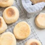 browned english muffins cooling on a wire rack on the kitchen counter.