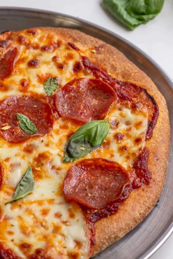 A half pizza on a pizza pan.