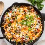 A cast iron skillet with a ground beef mixture and cheese fresh out of the oven.