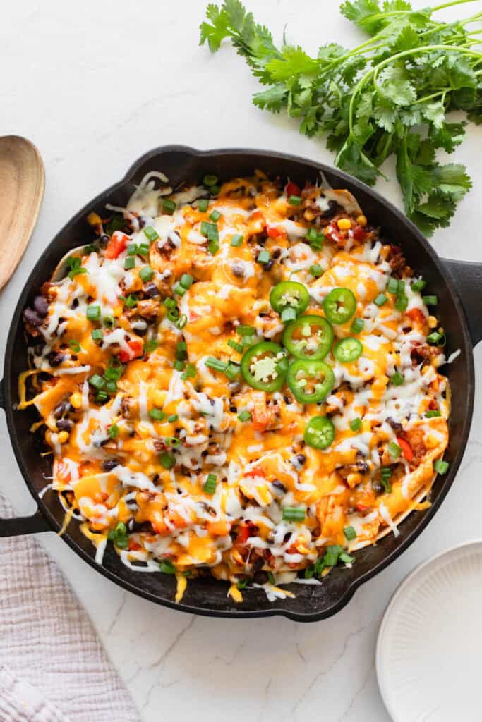 A cast iron skillet with a ground beef mixture and cheese fresh out of the oven.