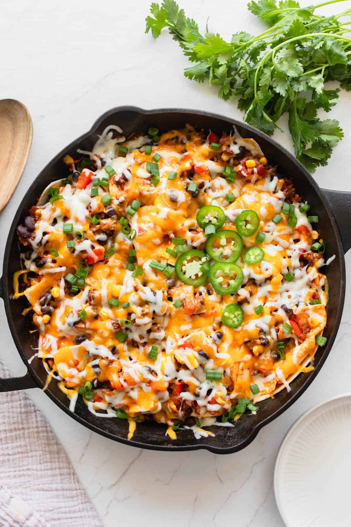 A cast iron skillet with a ground beef mixture and cheese fresh out of the oven.
