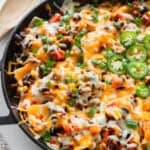 A cast iron skillet with a ground beef taco mixture.