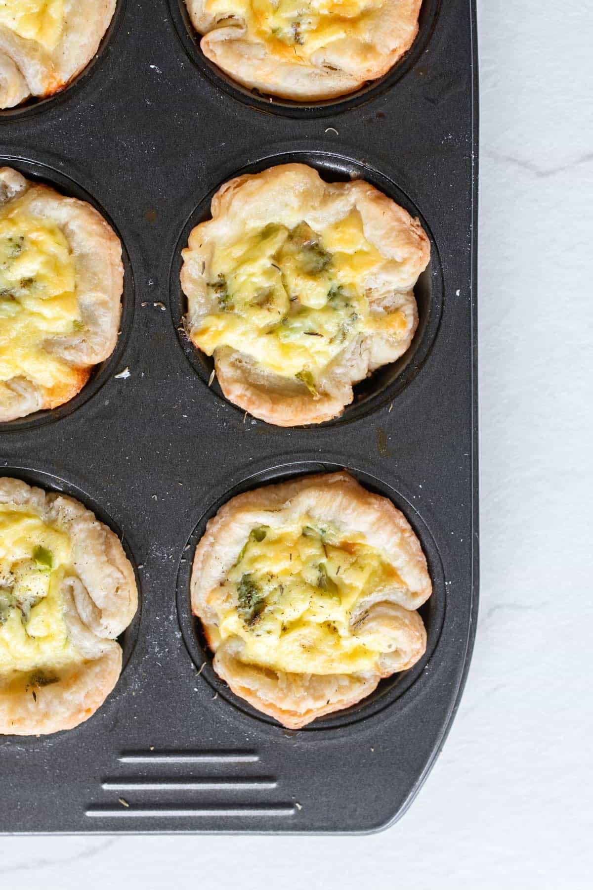 Baked mini quiches in a muffin tin.