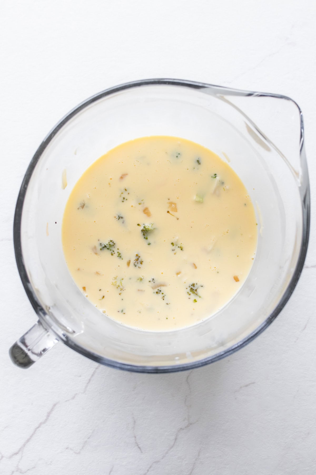 Egg mixture with add ins in a glass large measuring bowl.