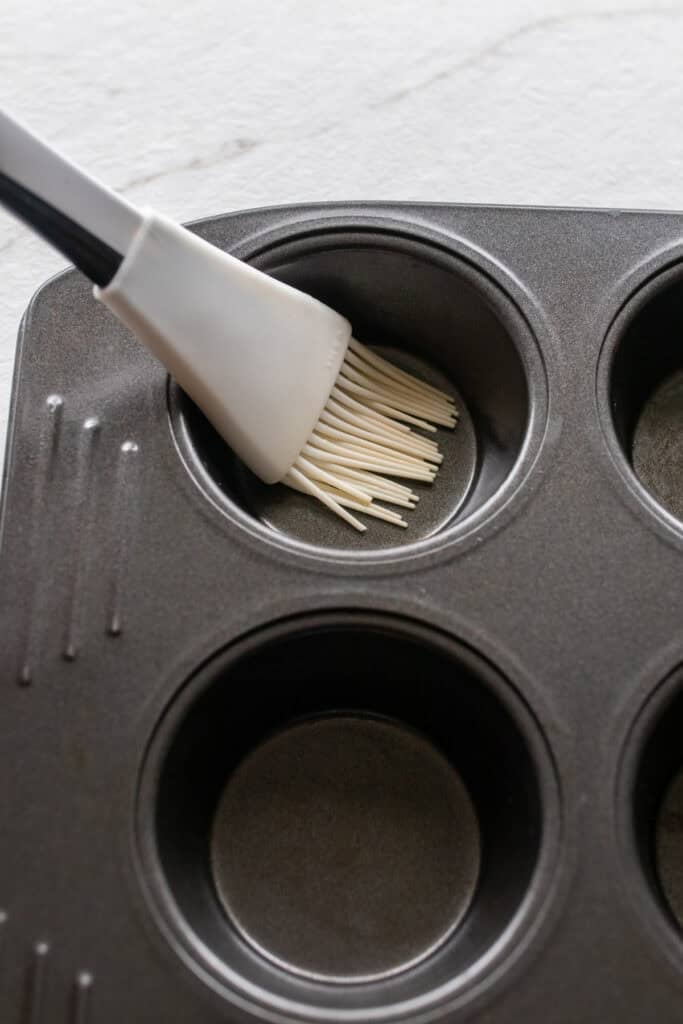 A silicone brush in a muffin tin.