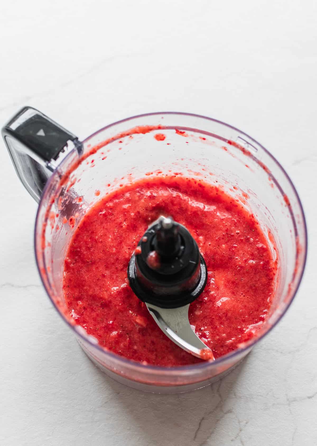 Strawberries combined in a food processor until smooth.