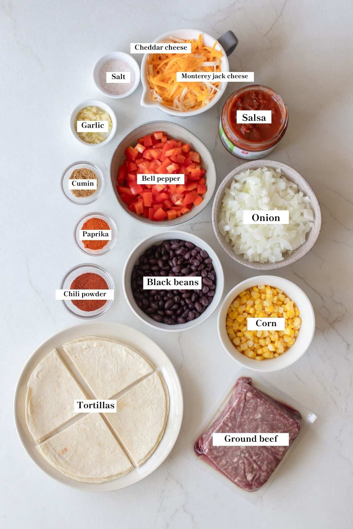 Ingredients for beef taco skillet in bowls on a counter top.