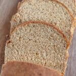Three slices of freshly milled sandwich bread cut from a loaf on a cutting board.