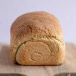 A loaf of bread on a wooden cutting board.