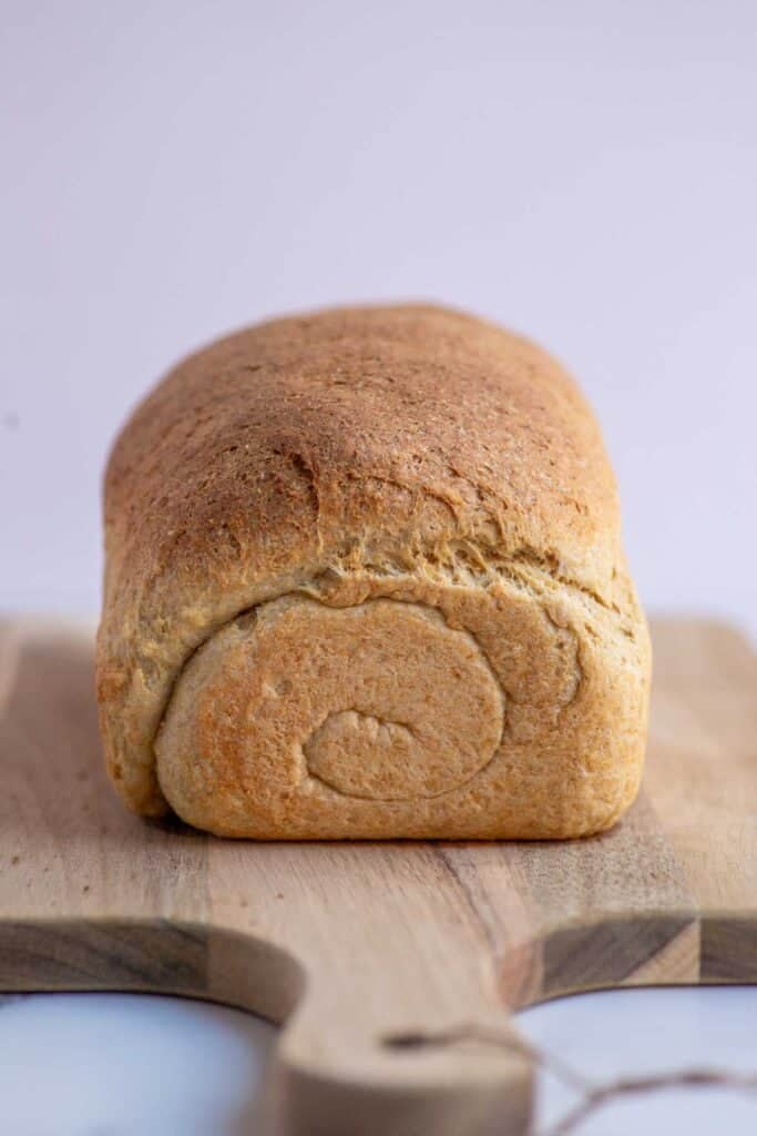A loaf of bread on a wooden cutting board.