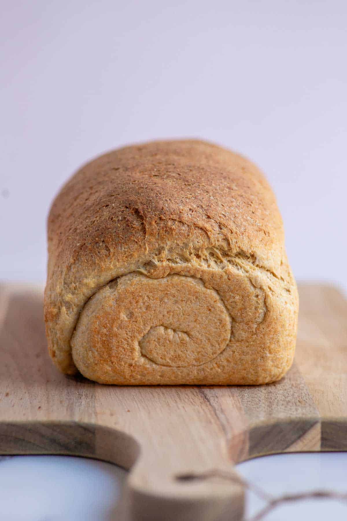 A loaf of bread on a wooden cutting board.