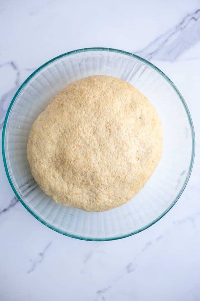 A dough ball in a glass bowl.