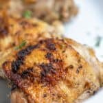 A close up of a chicken thigh on a platter.