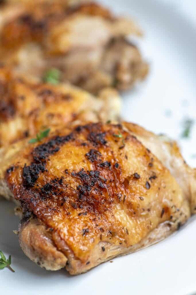 A close up of a chicken thigh on a platter.