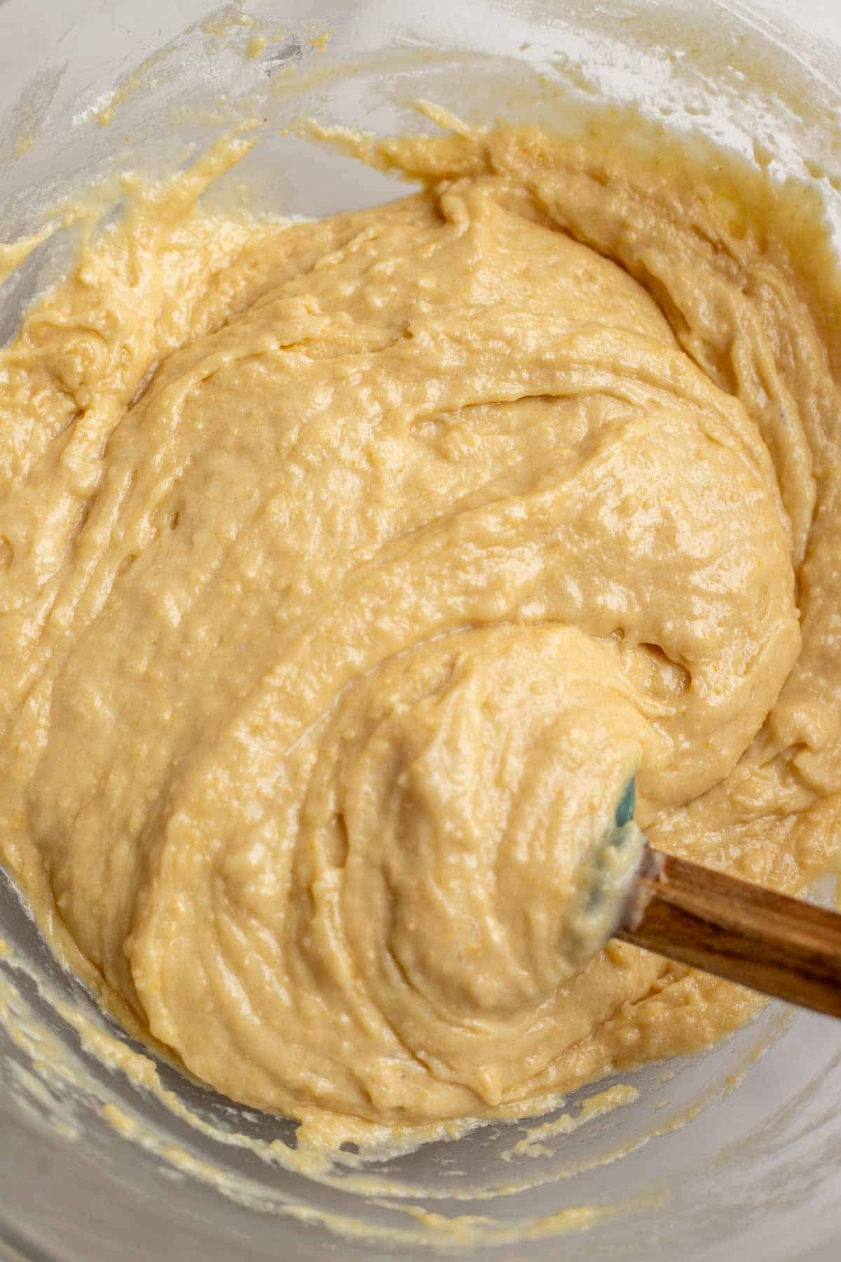 Wet and dry ingredients mixed together in a bowl with a spatula.
