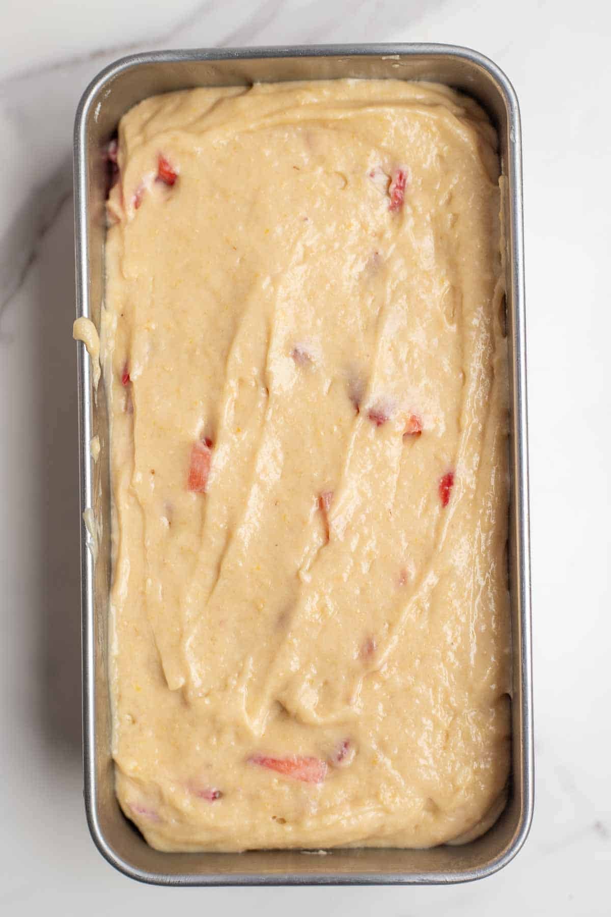 Quick bread batter spread into a loaf pan.