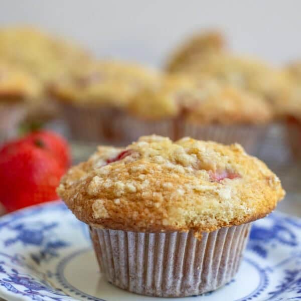 one sourdough strawberry muffin on a blue decorative dessert plate.