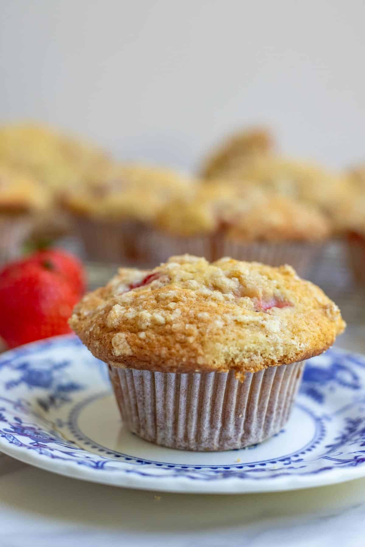 One sourdough strawberry muffin on a blue decorative dessert plate.