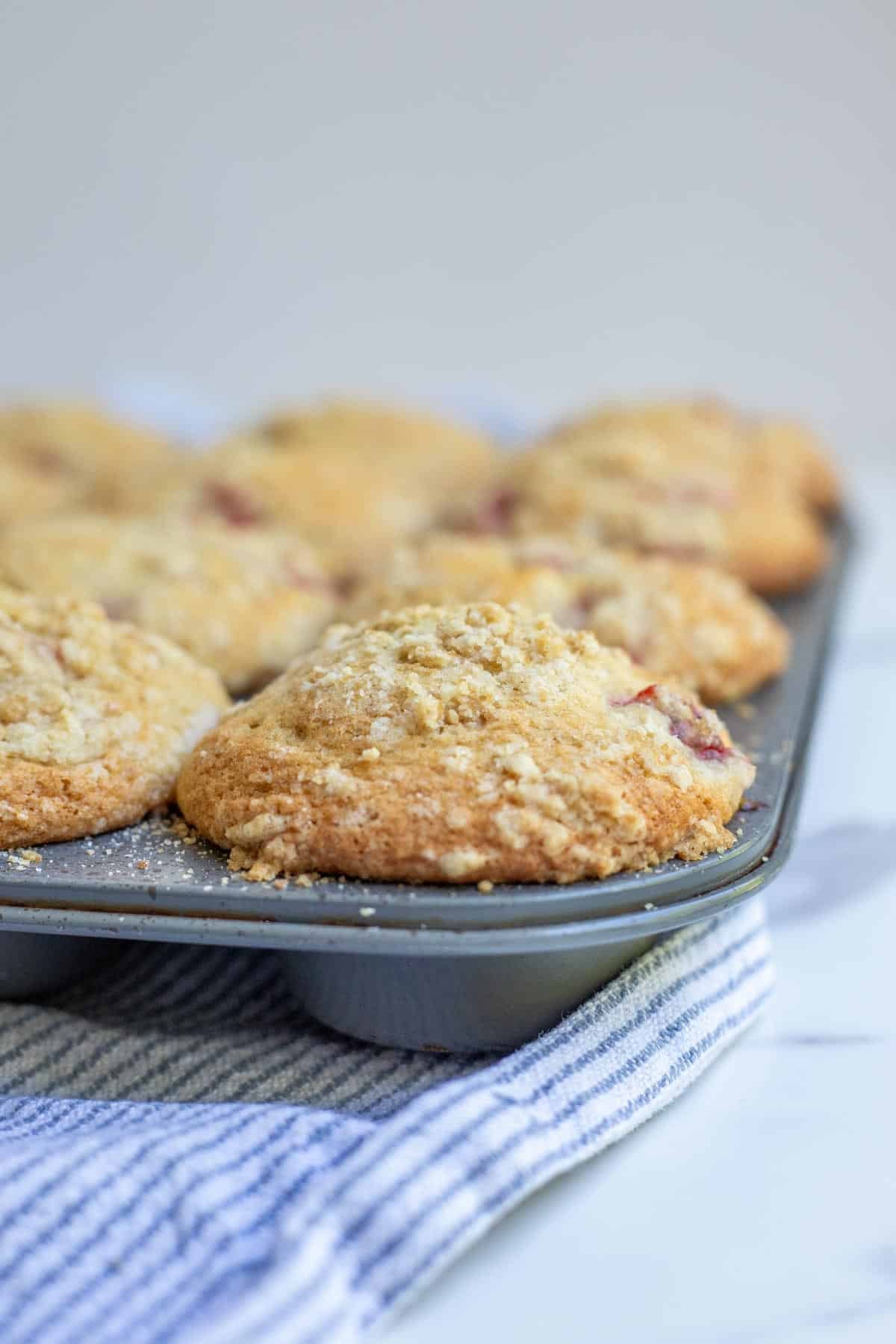 Fully cooked sourdough strawberry muffins in a muffin tin.